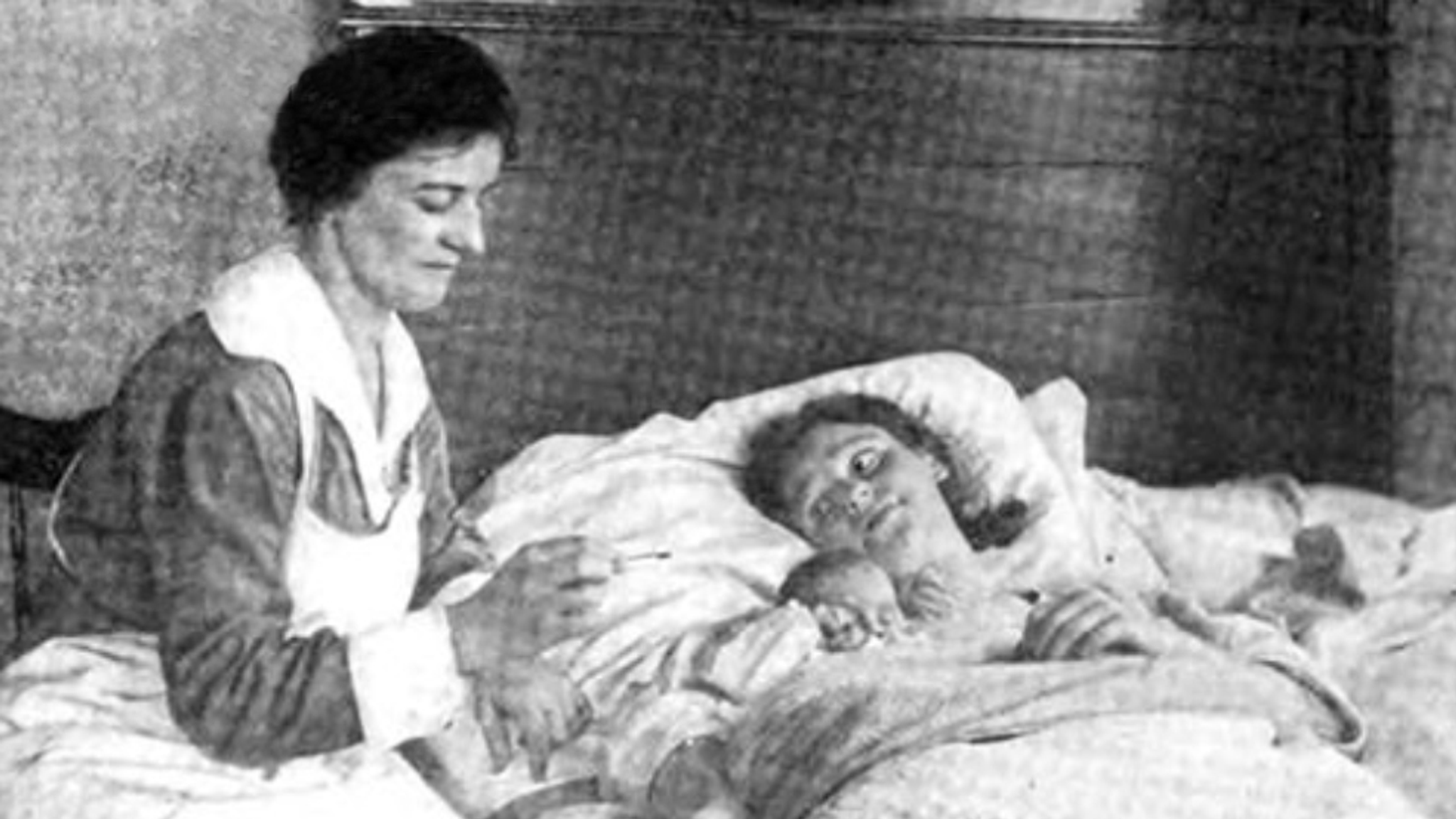 black and white shot of nurse Clementine Johnstone at a patients bedside