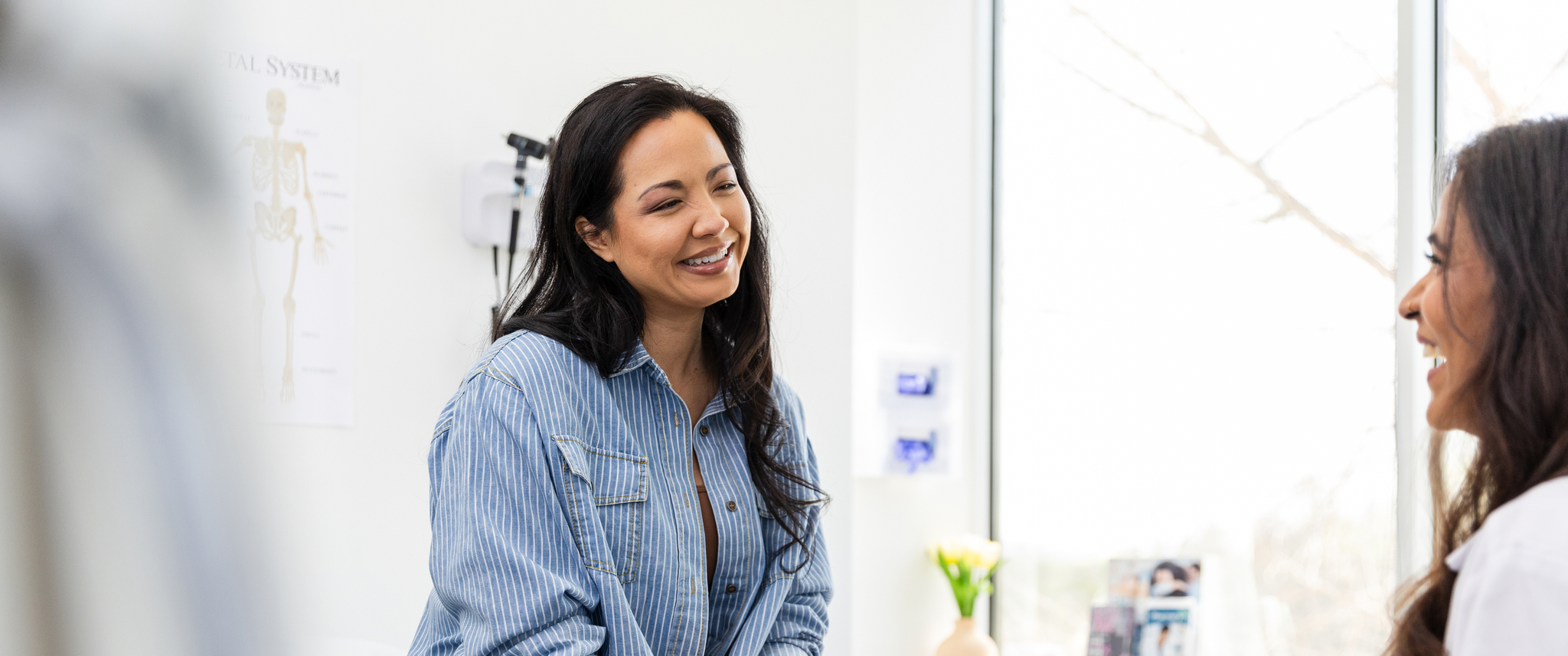 Patient and doctor laughing in exam room during appointment