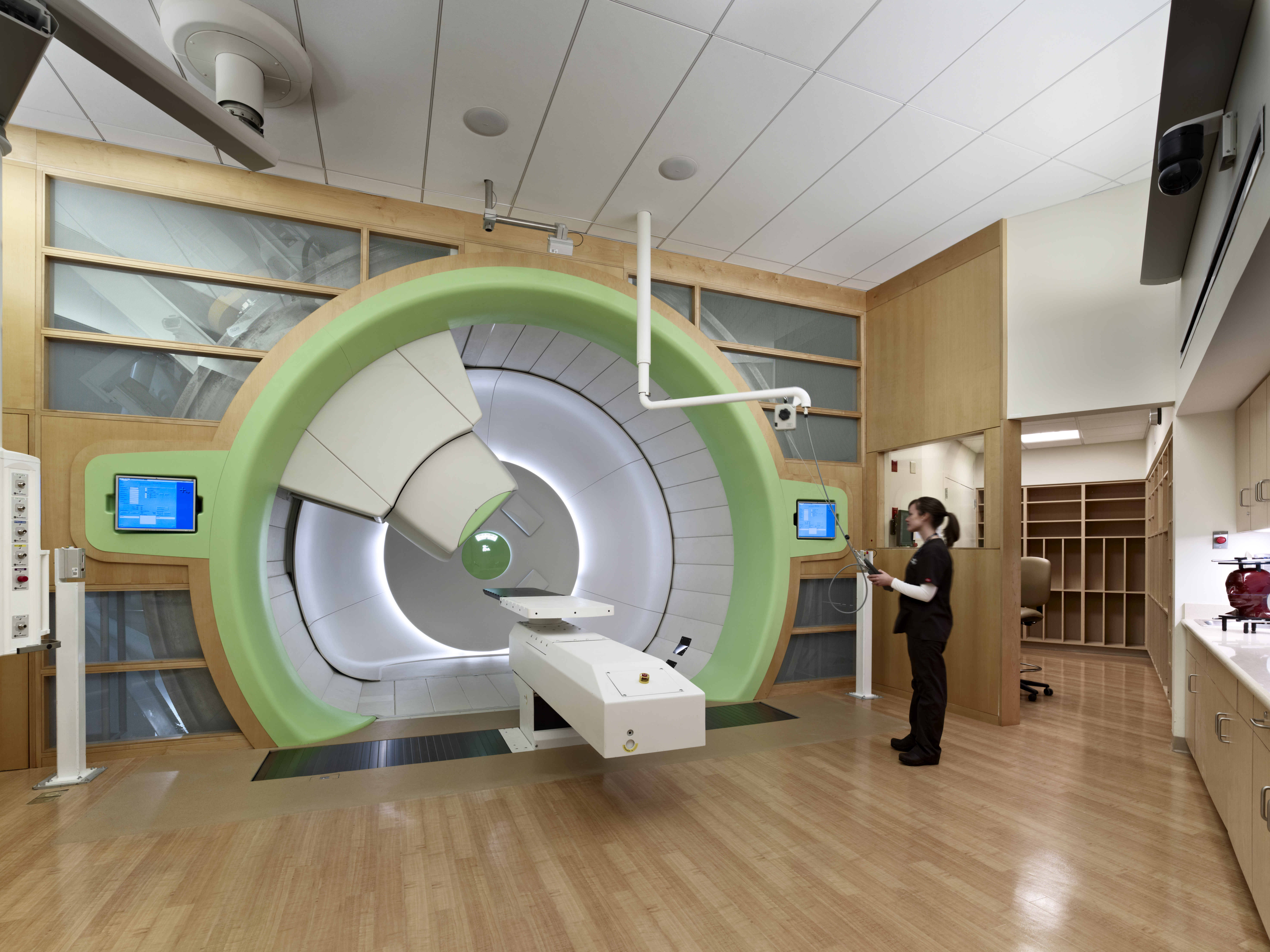 Nurse stands in front of gantry at Roberts Proton Therapy Center
