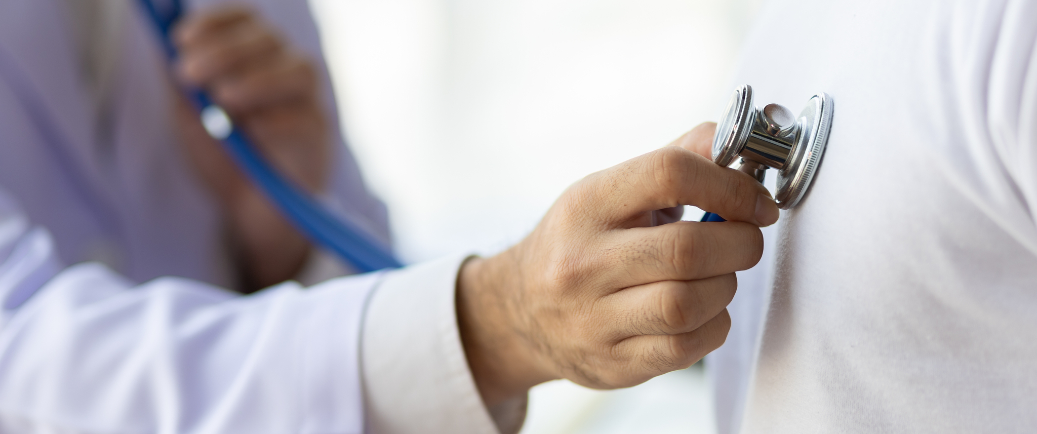 Doctor uses stethoscope to examine patient