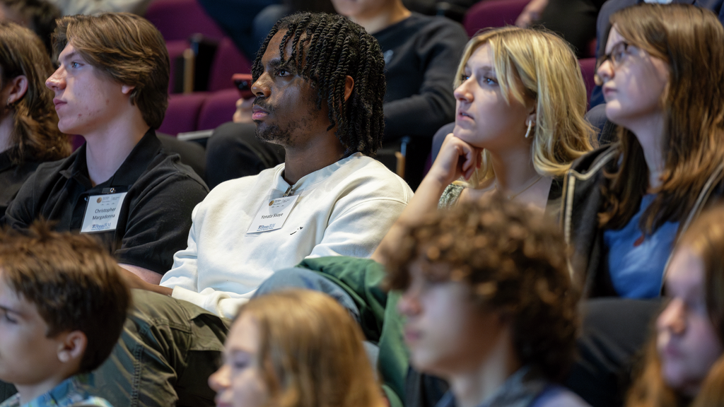 A group of high school students in an auditorium