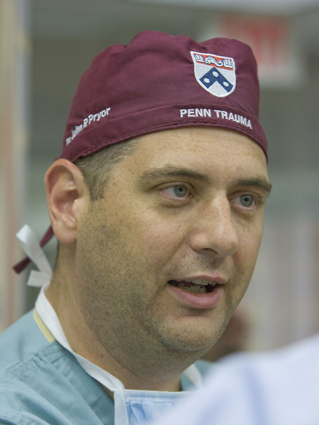 Close-up candid photo of the face of John P. Pryor, MD, wearing scrubs and a surgical cap