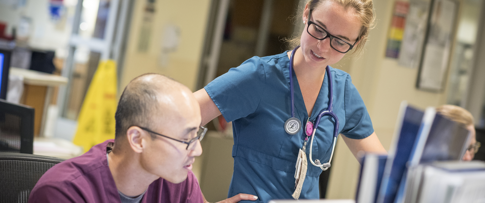 Nurses discussing a patient's symptoms at a desk at Doylestown Health