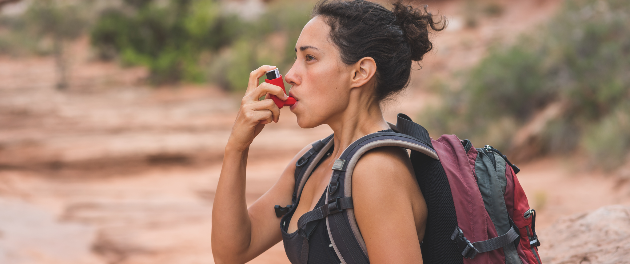Woman hiking with backpack and inhaler