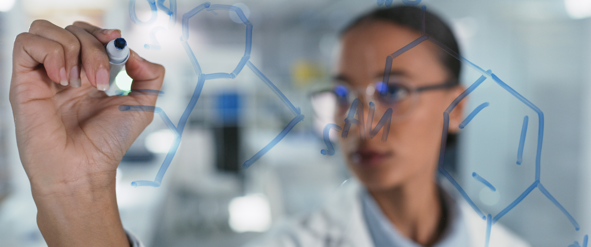 Scientist solves equations on a glass screen in a laboratory