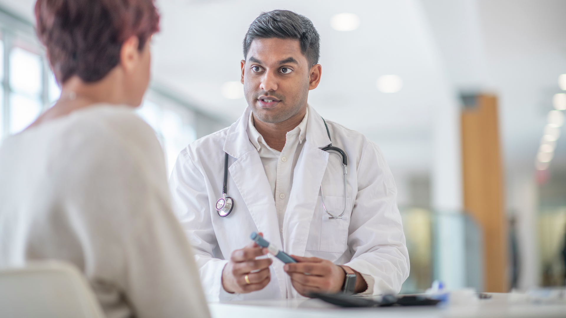 A female adult sitting across from her doctor  at check up appointment for a diabetic medical condition. 