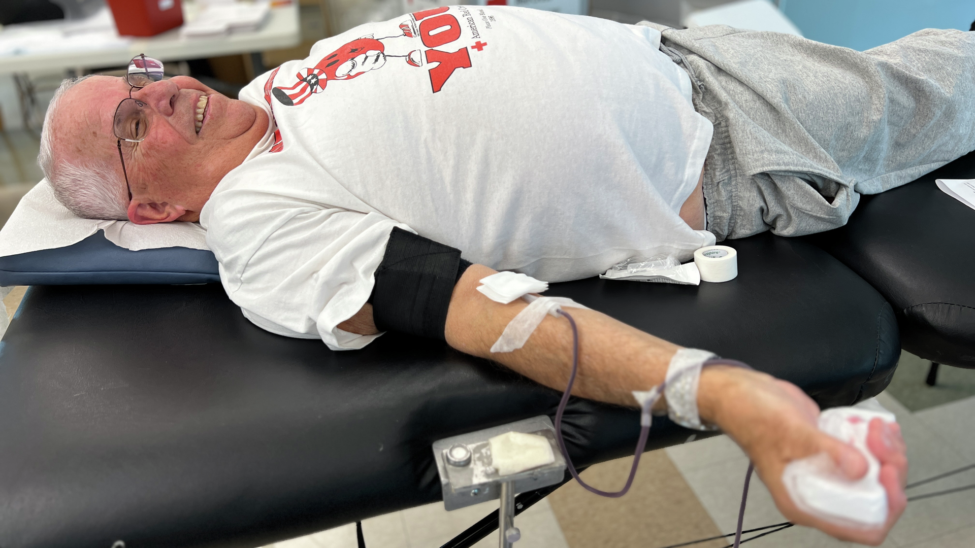 Marc A. Satalof lies on a black cot, making his final blood donation