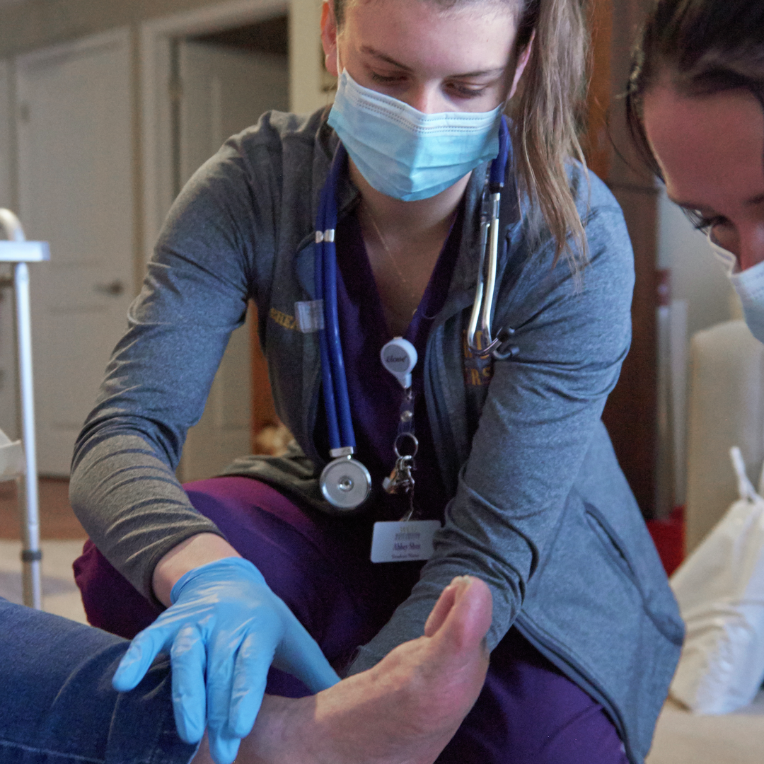 A student nurse examines a patient's foot