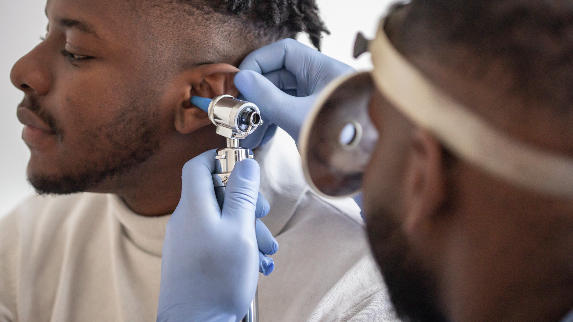 Close up of a male doctor carefully holding the ear of his patient to establish a clearer view of the inside of his ear