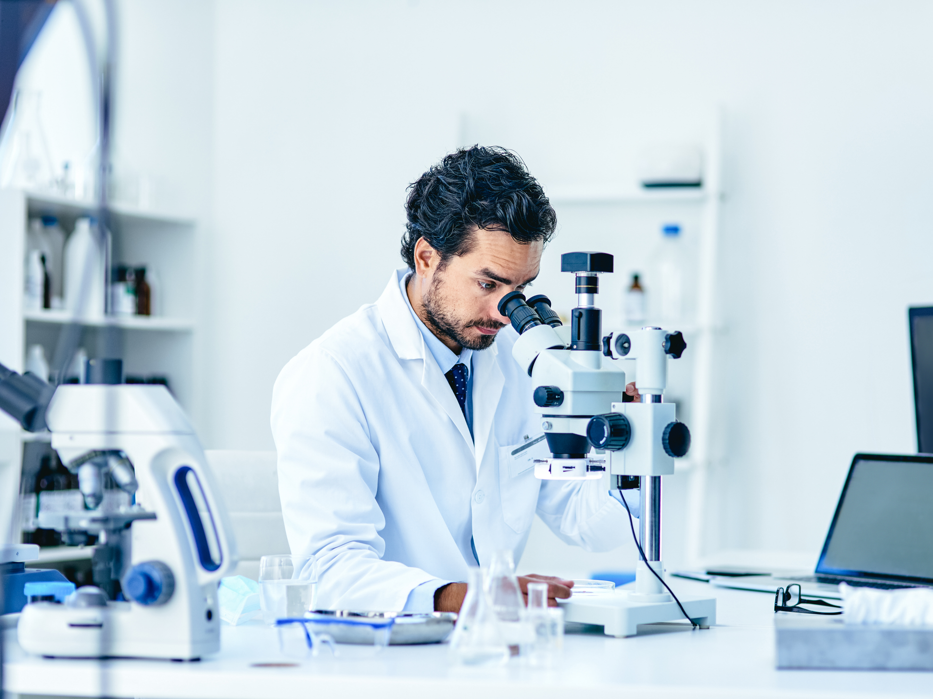 Shot of a young scientist using a microscope in a lab