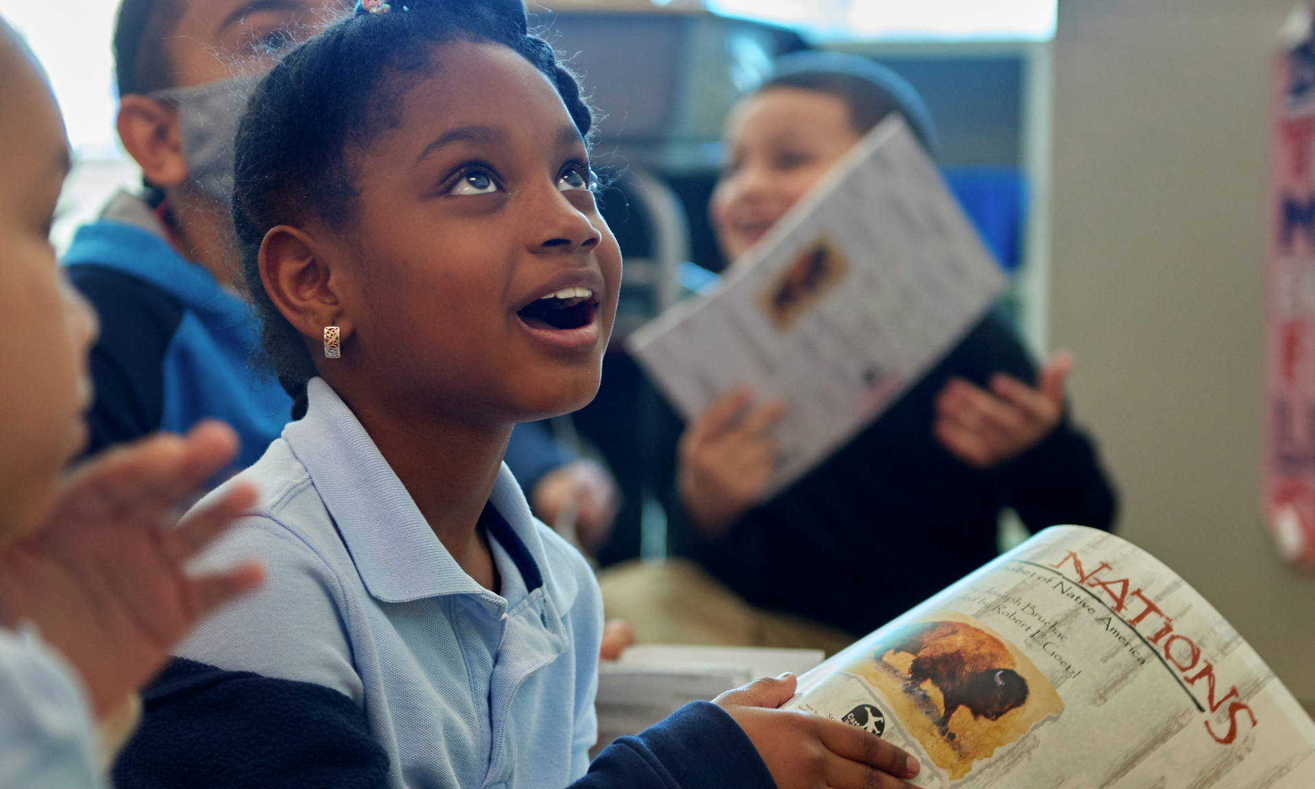 A young girl looks up with awe