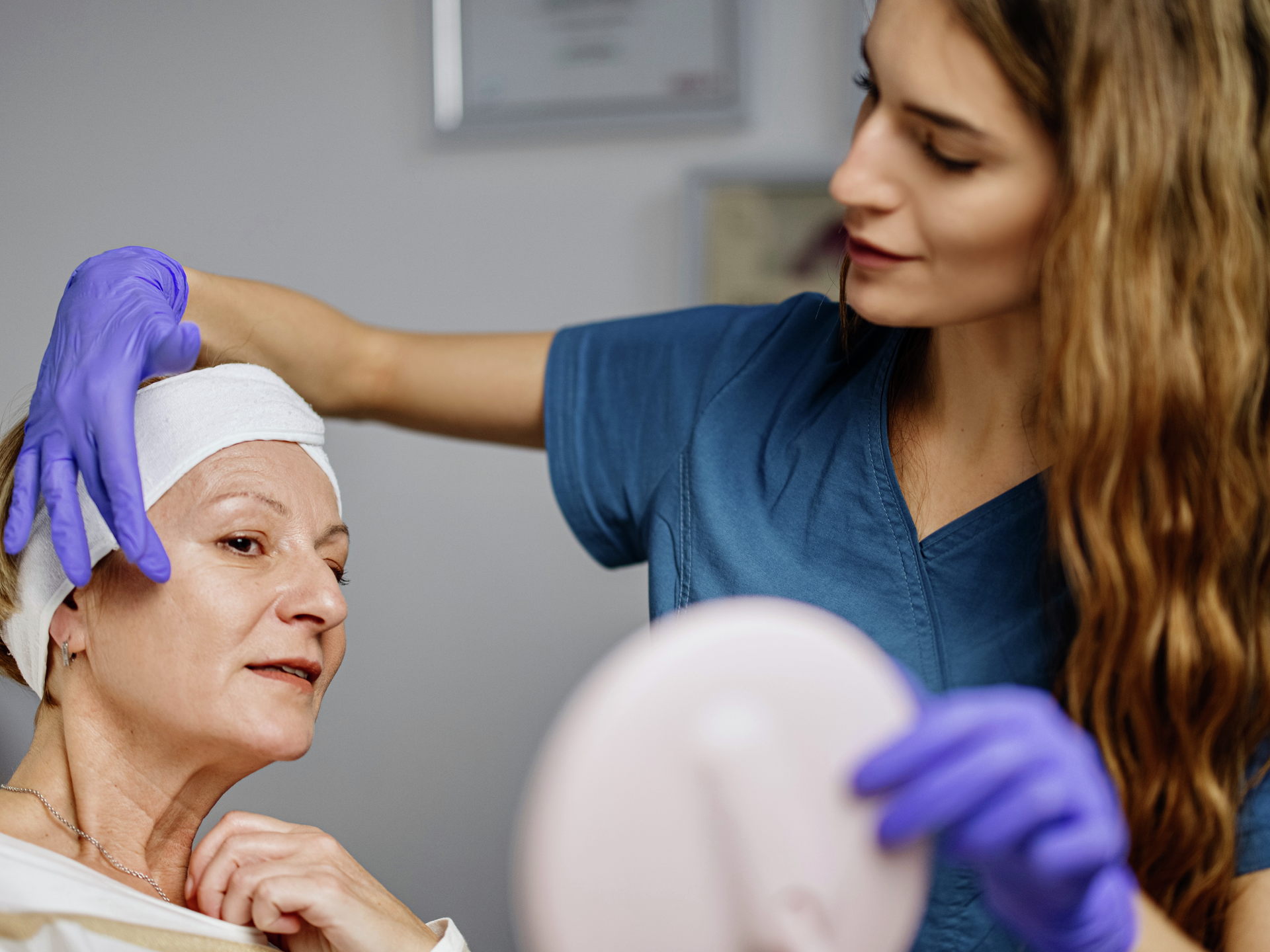  Young female doctor talks about beauty treatments during a consultation with a mature woman patient