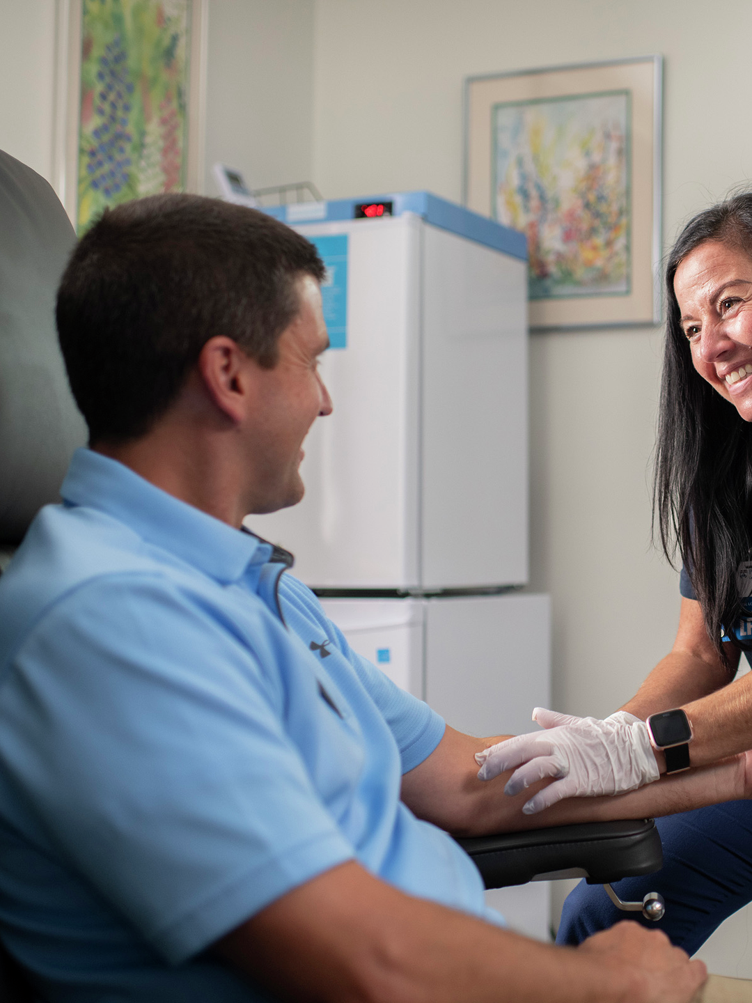 Vita Mazzola smiles interacting with a patient in an exam room