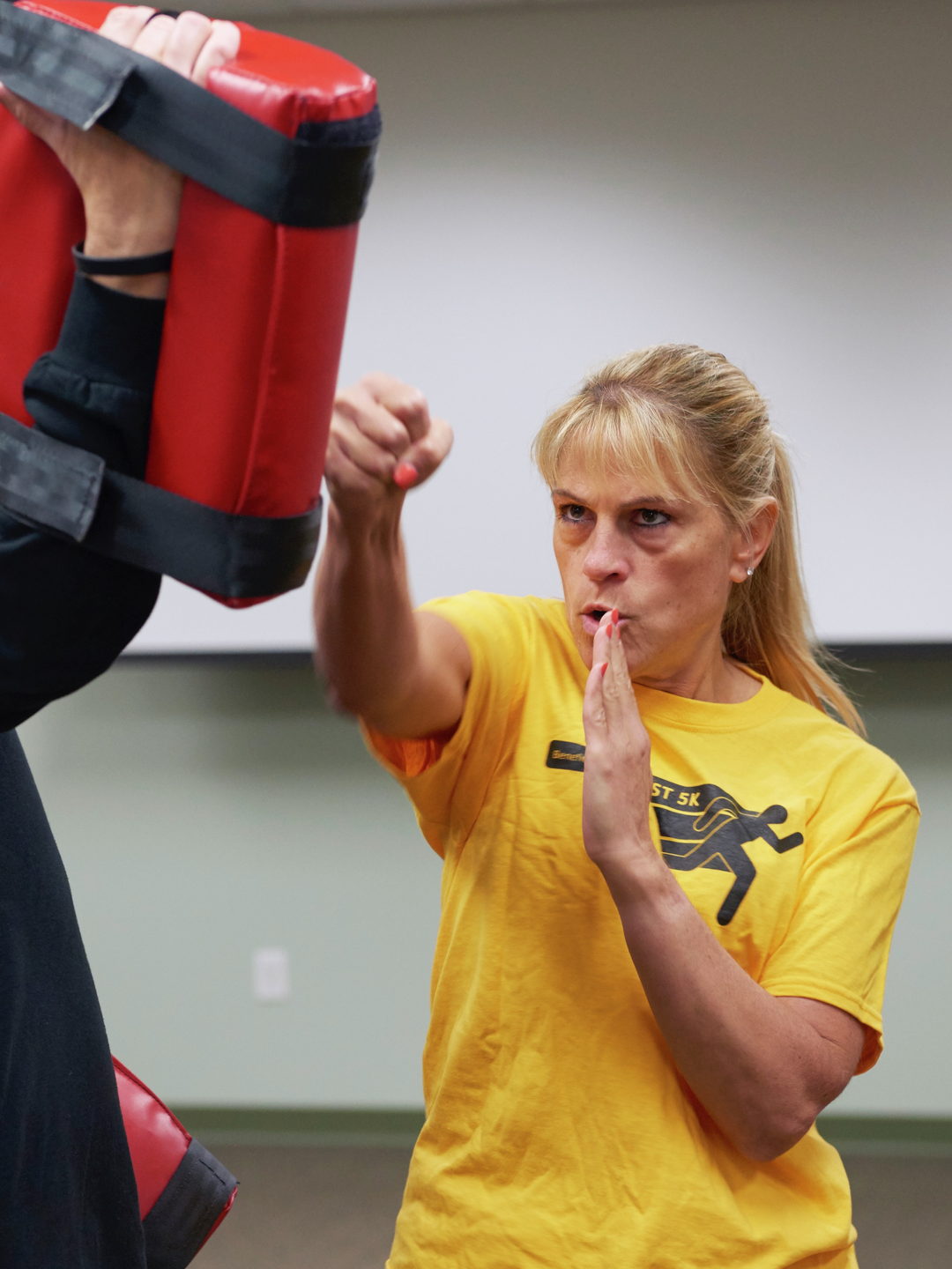 Deborah Millar punches at a pad held by a male instructor