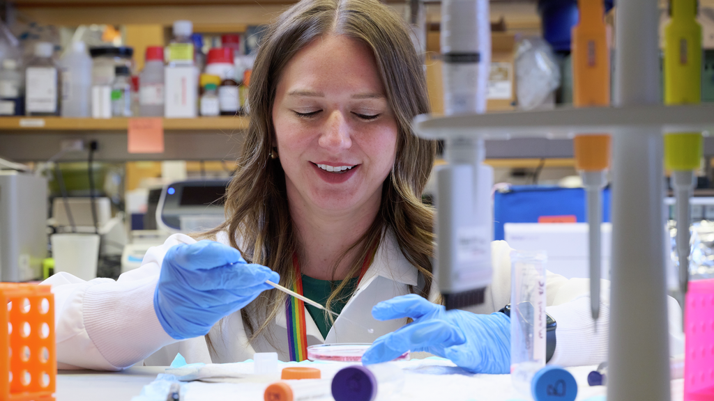 Kathleen O’Neill examining a petri dish in a lab