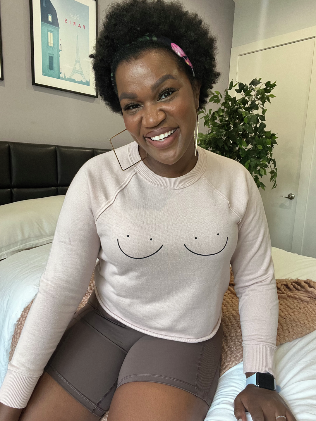 Brooklyn Olumba wearing a shirt with a minimalist line drawing of breasts on the front
