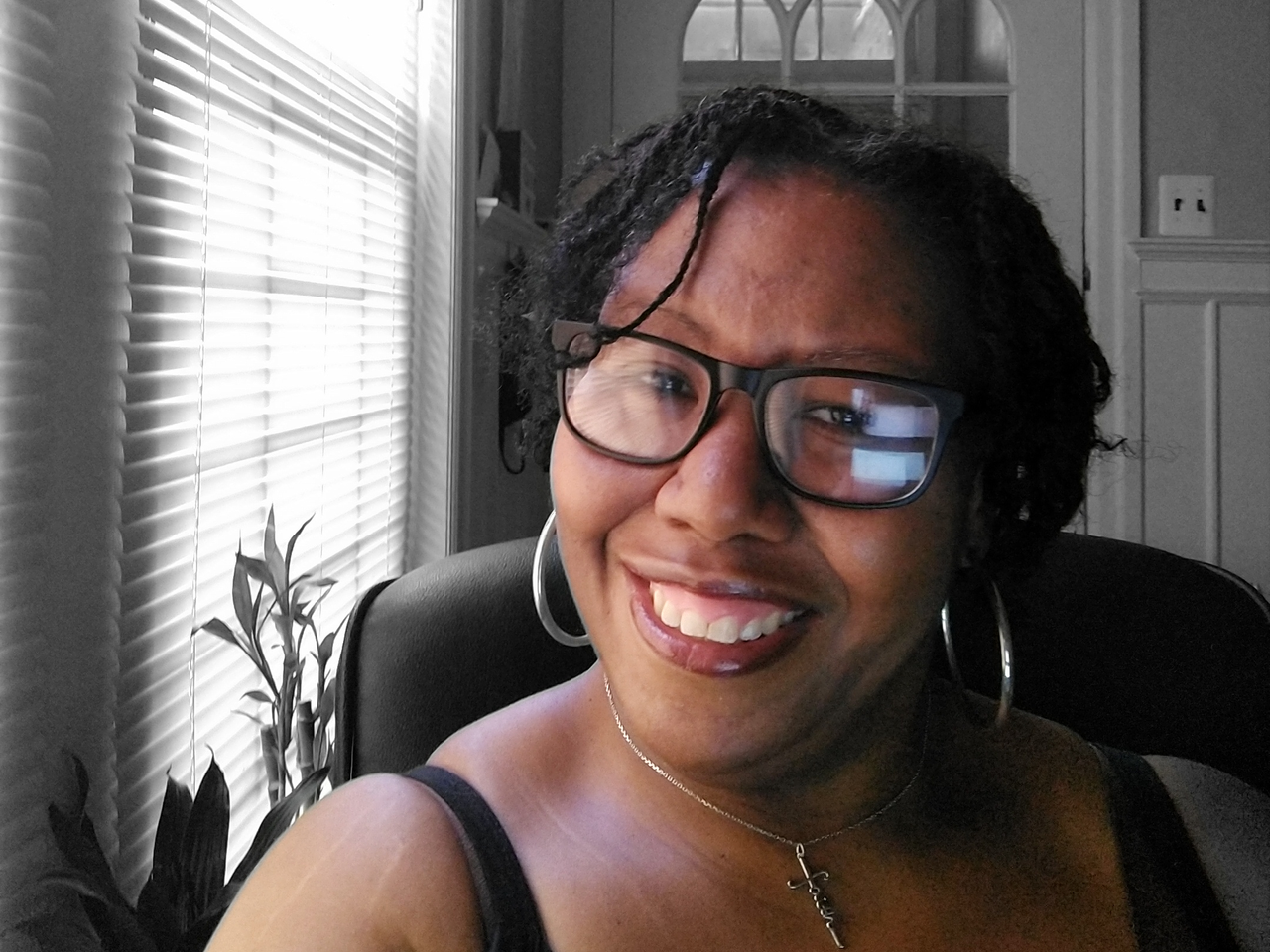 A selfie taken by Stacy Hill, a smiling Black woman wearing glasses