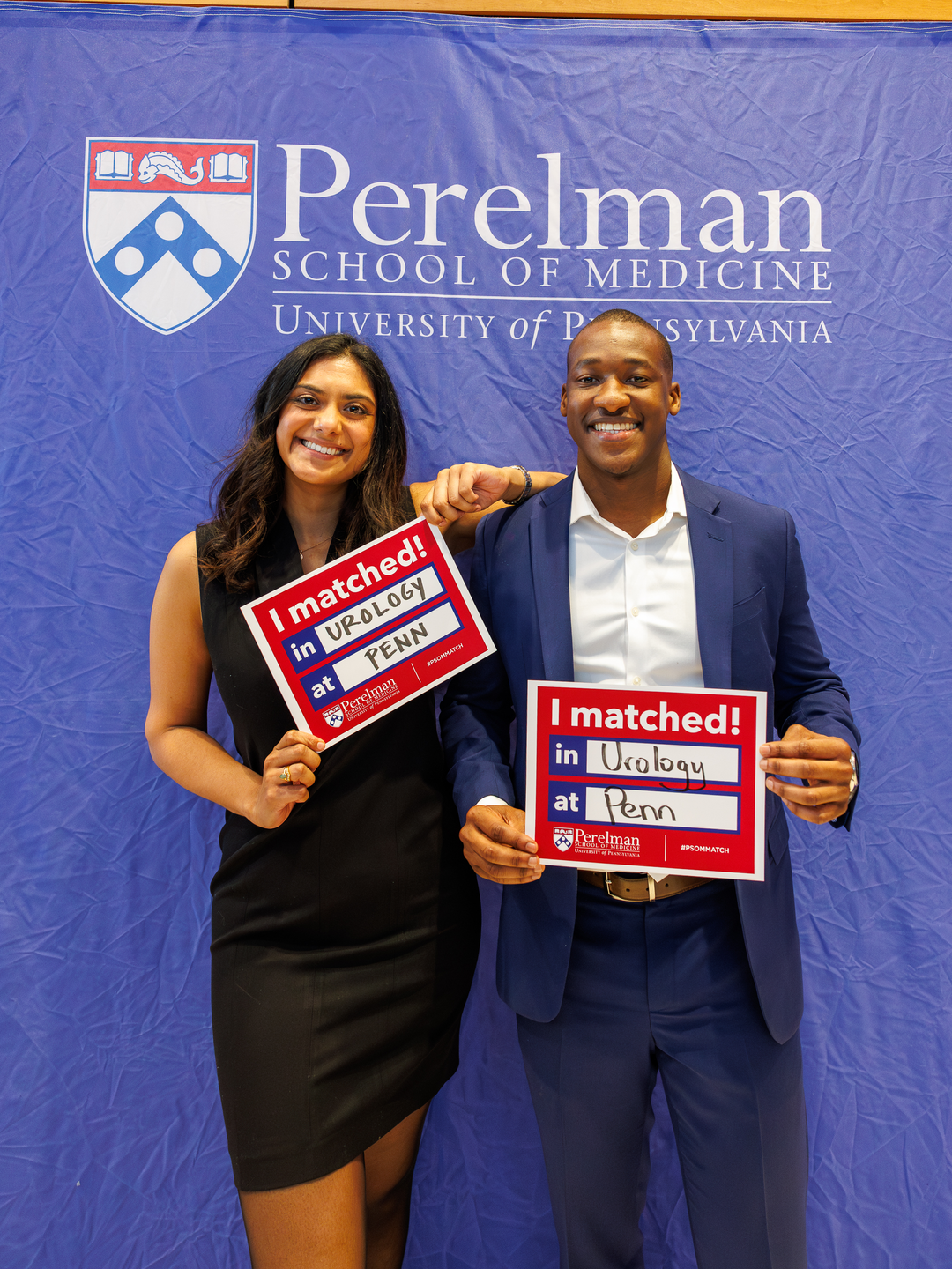 Avanti Ragnekar and Sydney Chambule hold signs showing they both matched at Penn Urology