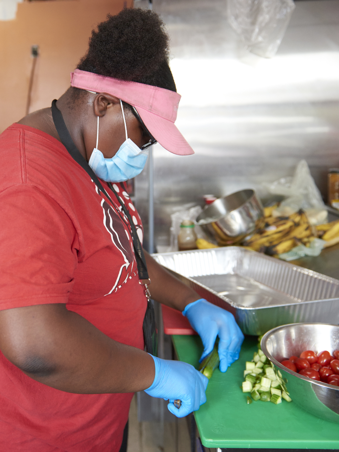 A woman chops cucumbers at a kitchen counter
