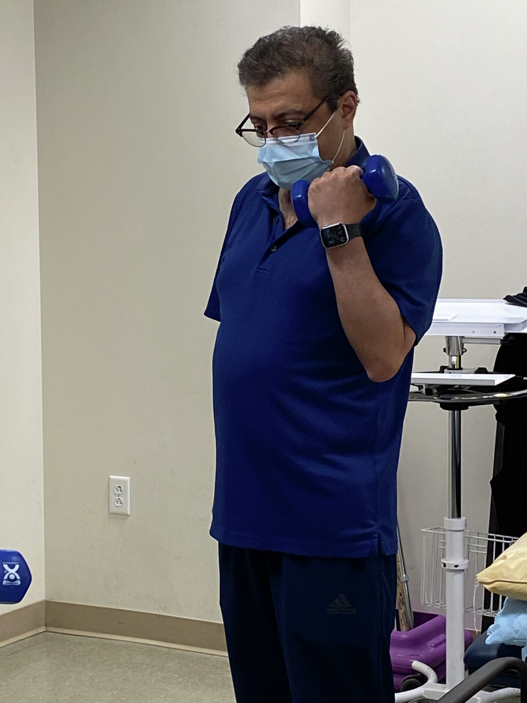 Rahmanian lifts a hand weight as a physical therapy exercise